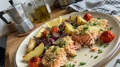 Bastoncini di salmone al forno croccanti con patate e pomodorini in teglia